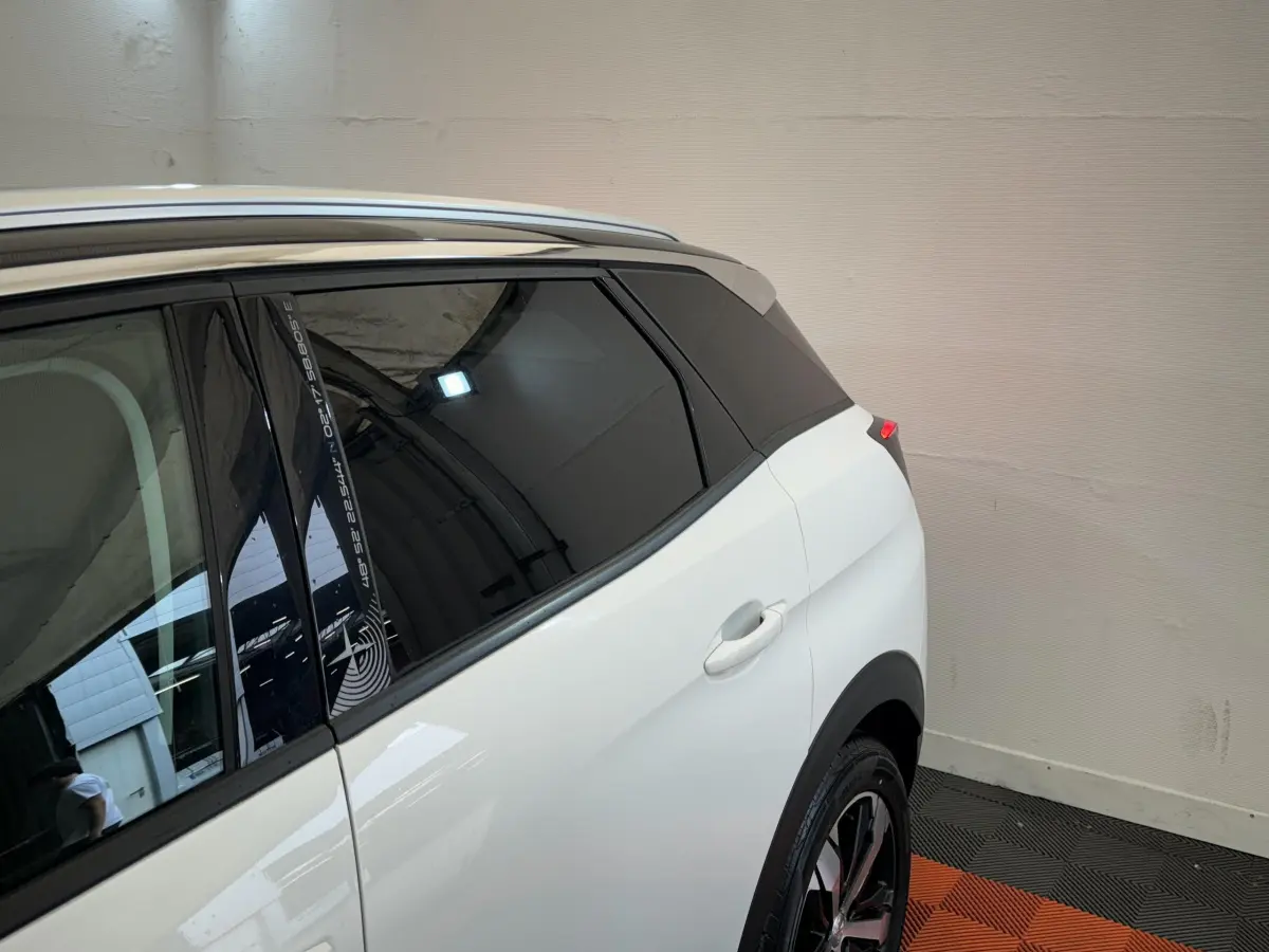 Vue arrière côté droit du Peugeot 3008 blanc avec vitres teintées et jante alliage visible en intérieur fermé.