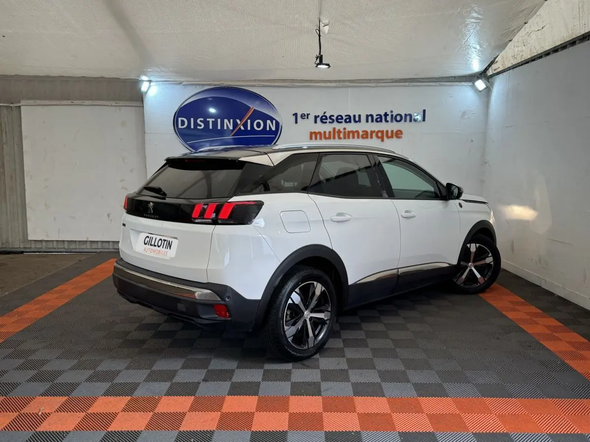 Peugeot 3008 blanc vue 3/4 arrière droit, toit noir, feux arrière LED et jantes alliage bicolores.
