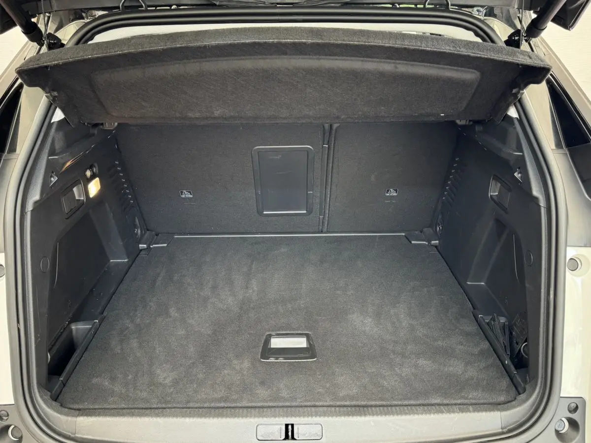 Coffre ouvert du Peugeot 3008 blanc vue arrière, montrant un espace de chargement propre et bien aménagé.