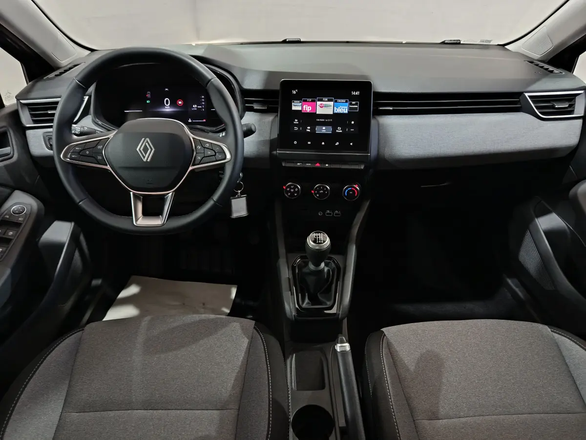 Intérieur avant de la Renault Clio 2025 gris foncé, volant multifonctions, écran tactile central et boîte manuelle.