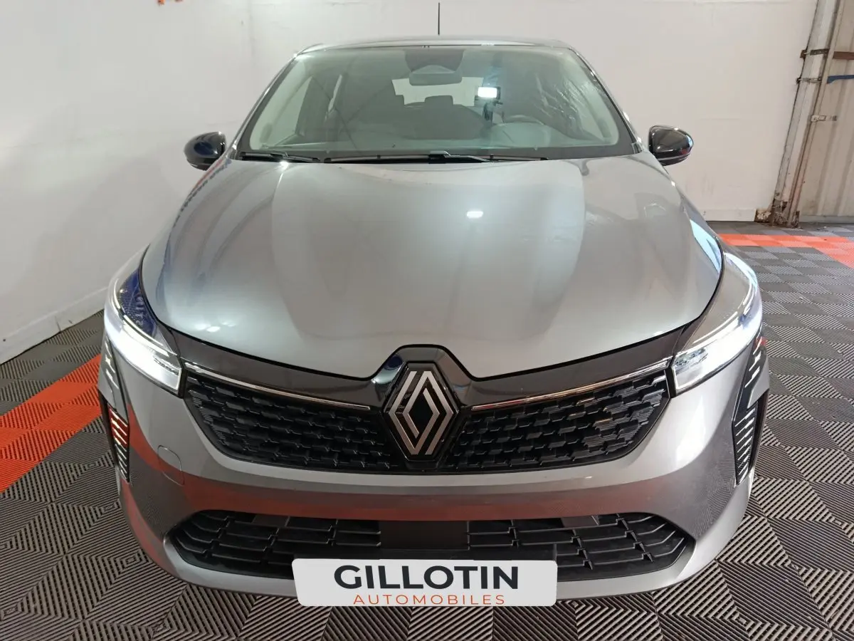 Renault Clio Evolution Blue dCi 100 2025 gris foncé vue de face avec calandre noire et phares LED allumés.