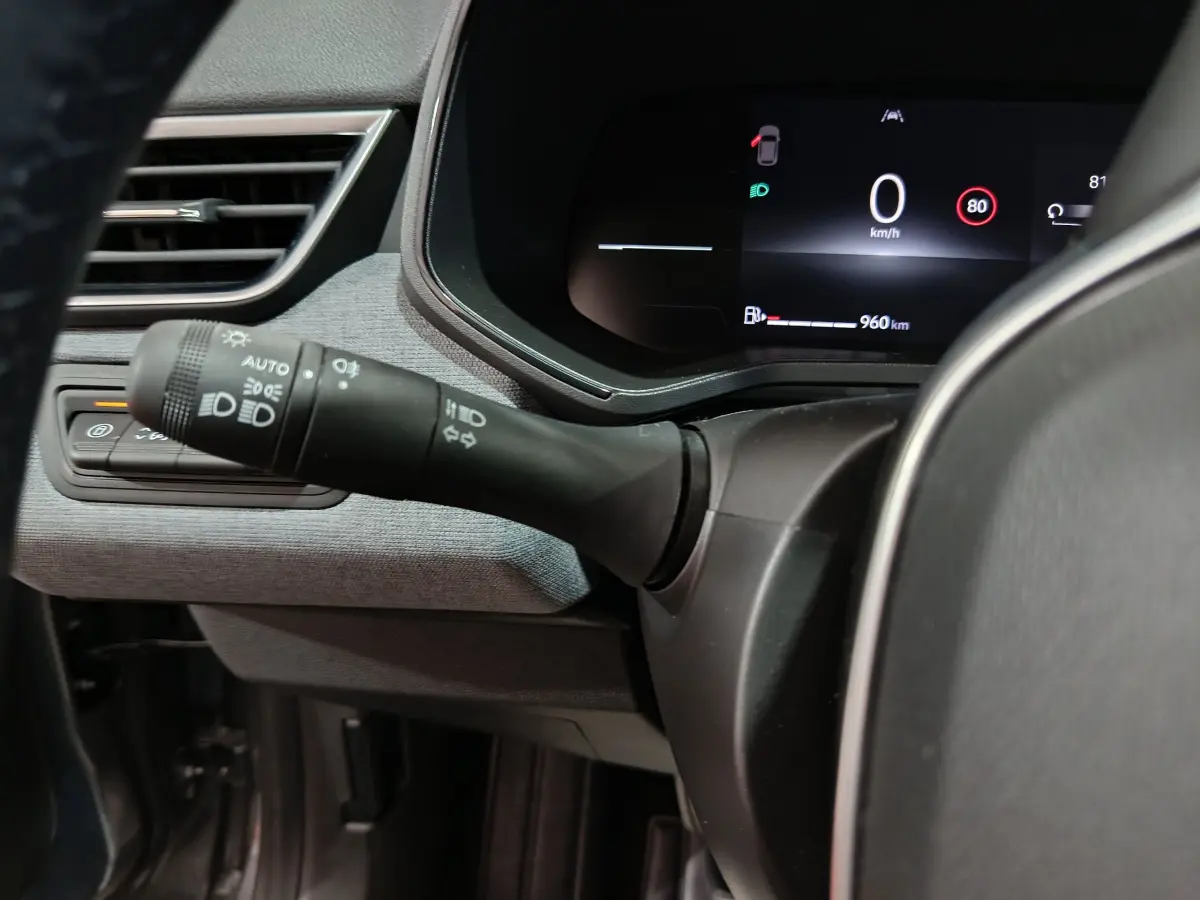 Gros plan sur la commande des phares et le combiné d'instruments digital de la Renault Clio Evolution Blue dCi 100 gris foncé.