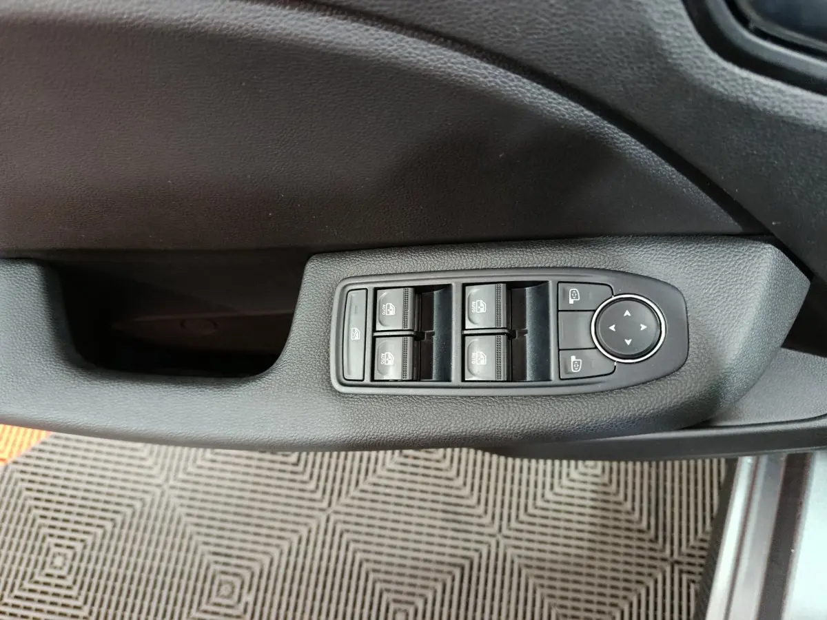 Commande des vitres et réglage des rétroviseurs côté conducteur sur porte intérieure noire d'une Renault Clio gris foncé 2025.