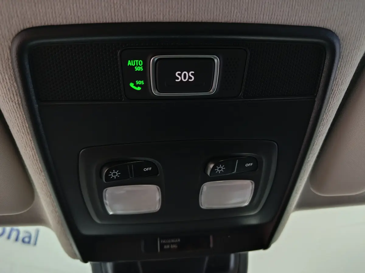 Vue en gros plan du plafonnier intérieur de la Renault Clio gris foncé, avec bouton SOS et commandes d'éclairage.