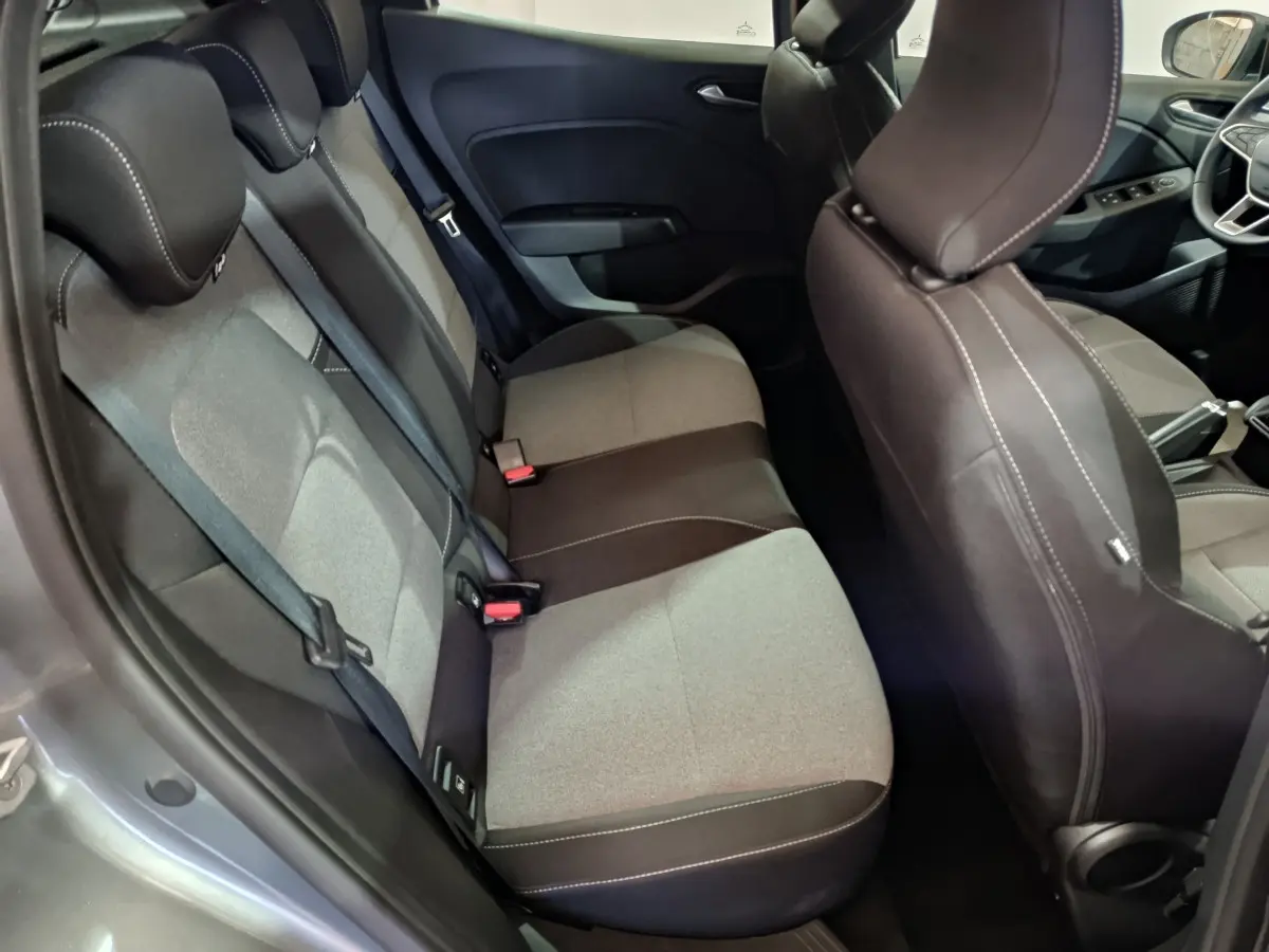 Vue intérieure côté gauche montrant la banquette arrière bi-ton gris et noir de la Renault Clio Evolution Blue dCi 100 2025.
