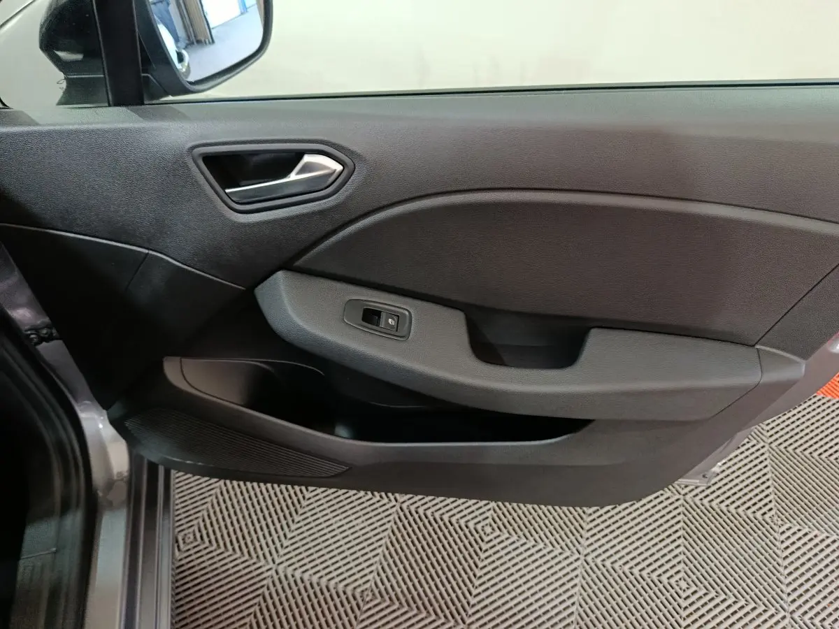 Vue côté gauche de la porte intérieure noire de la Renault Clio Evolution Blue dCi 100 -25 avec commande de vitre électrique.