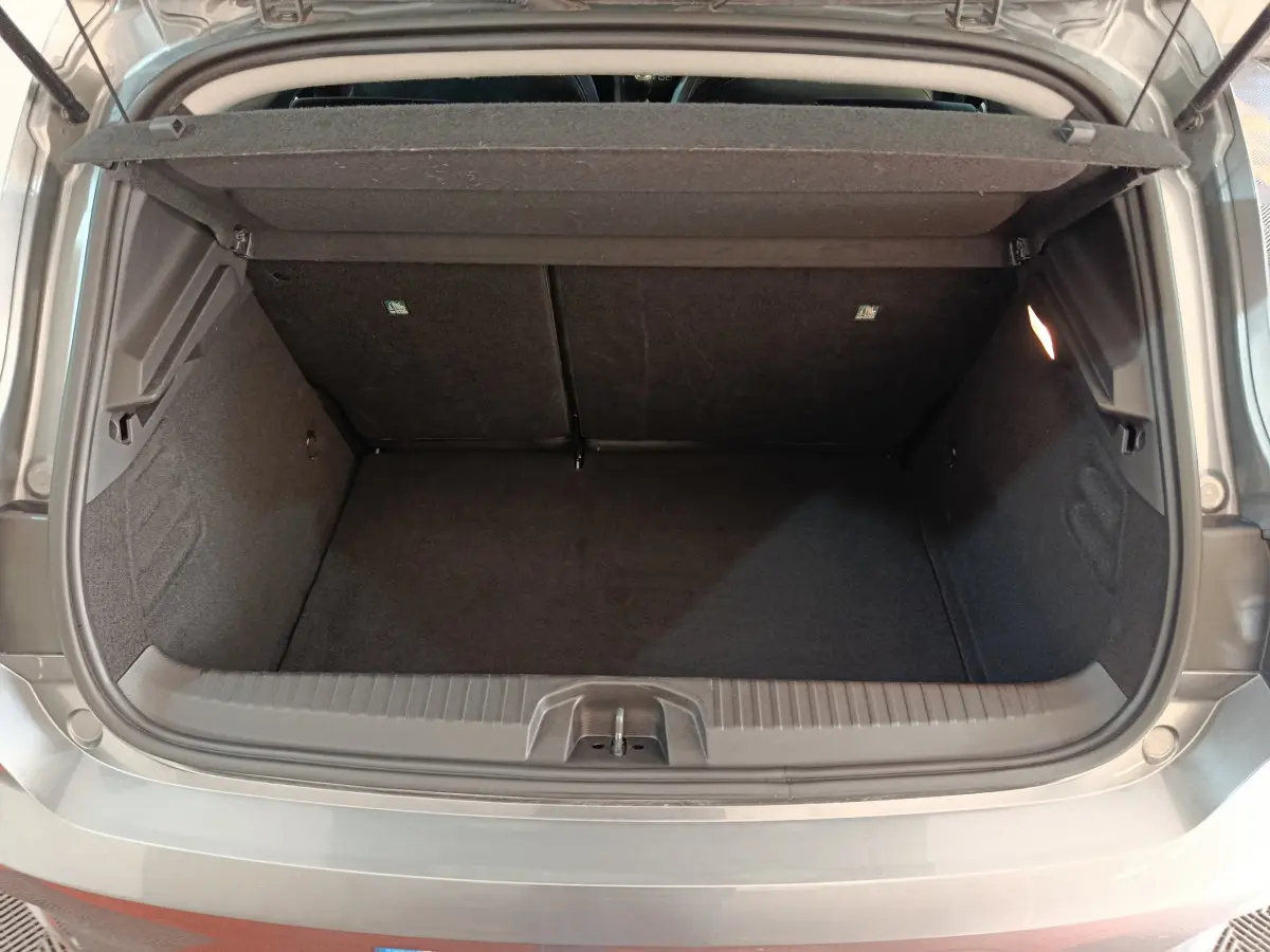 Coffre ouvert vu de l'arrière d'une Renault Clio gris foncé Evolution Blue dCi 100 -25, espace de chargement vide.