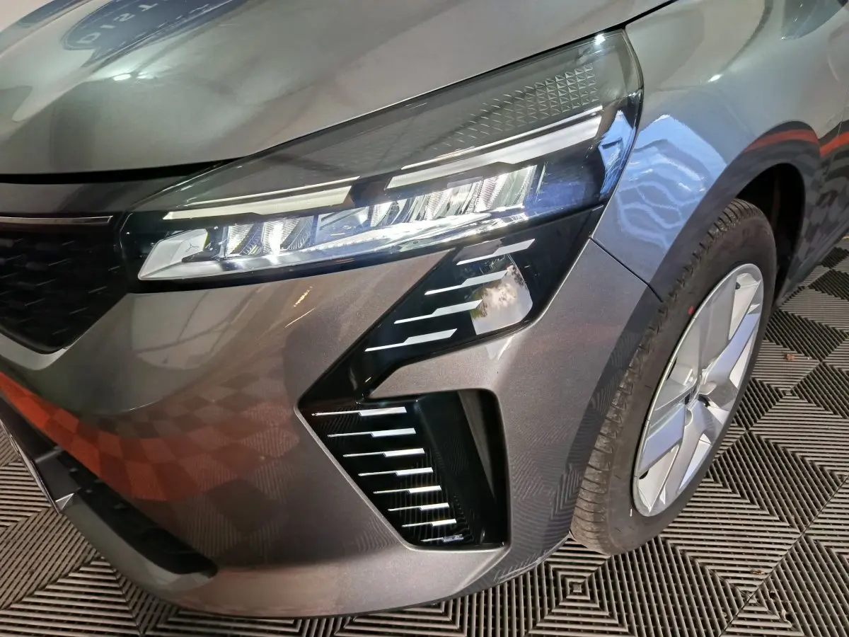 Gros plan sur l'avant droit gris foncé de la Renault Clio Evolution Blue dCi 100 avec phares LED distinctifs et jante visible.