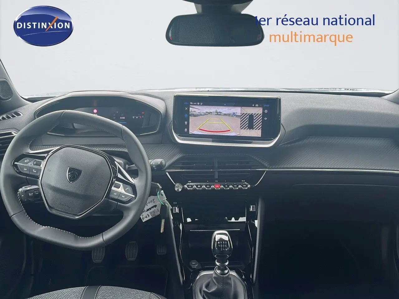 Intérieur du Peugeot 2008 2025 vu de face, tableau de bord noir avec écran tactile et levier de vitesse manuel.