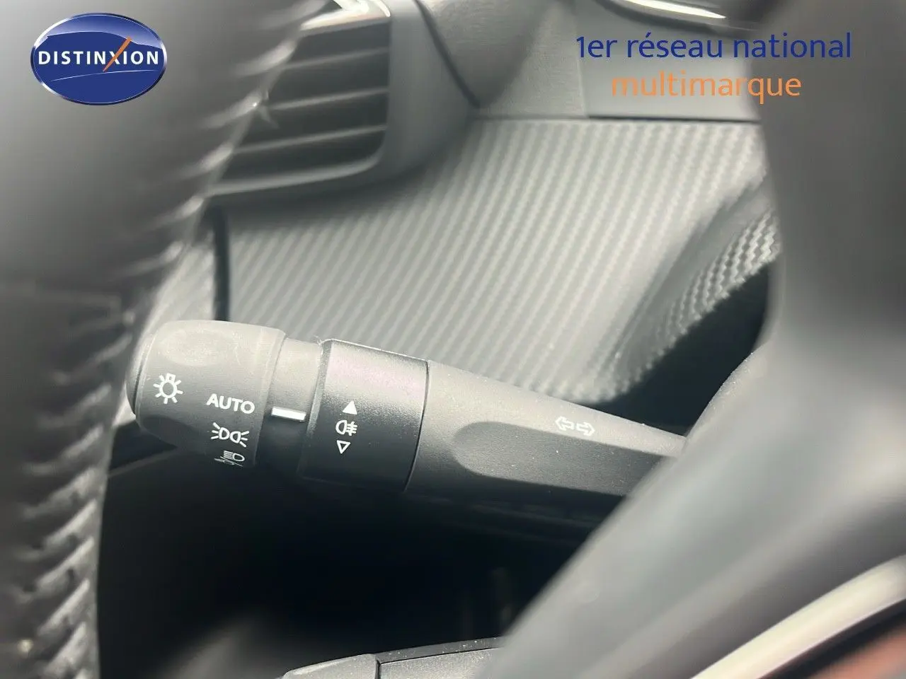 Gros plan sur la commande des phares et clignotants dans l'habitacle d'une Peugeot 2008 blanche 2025.