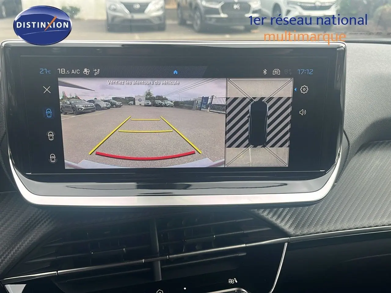 Écran intérieur affichant la caméra de recul et vue 360° d'une Peugeot 2008 blanche, tableau de bord moderne.