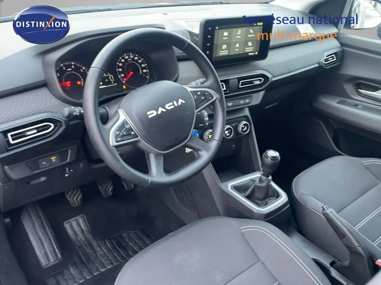 Gros plan sur la manette des feux à gauche du volant dans l’habitacle sombre du Dacia Jogger 2025.