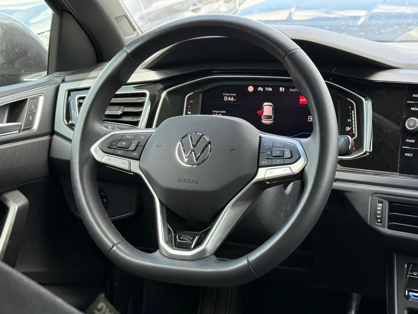 Vue rapprochée du volant cuir multifonction gris du Volkswagen Taigo 1.0 TSI R-Line avec tableau de bord digital.