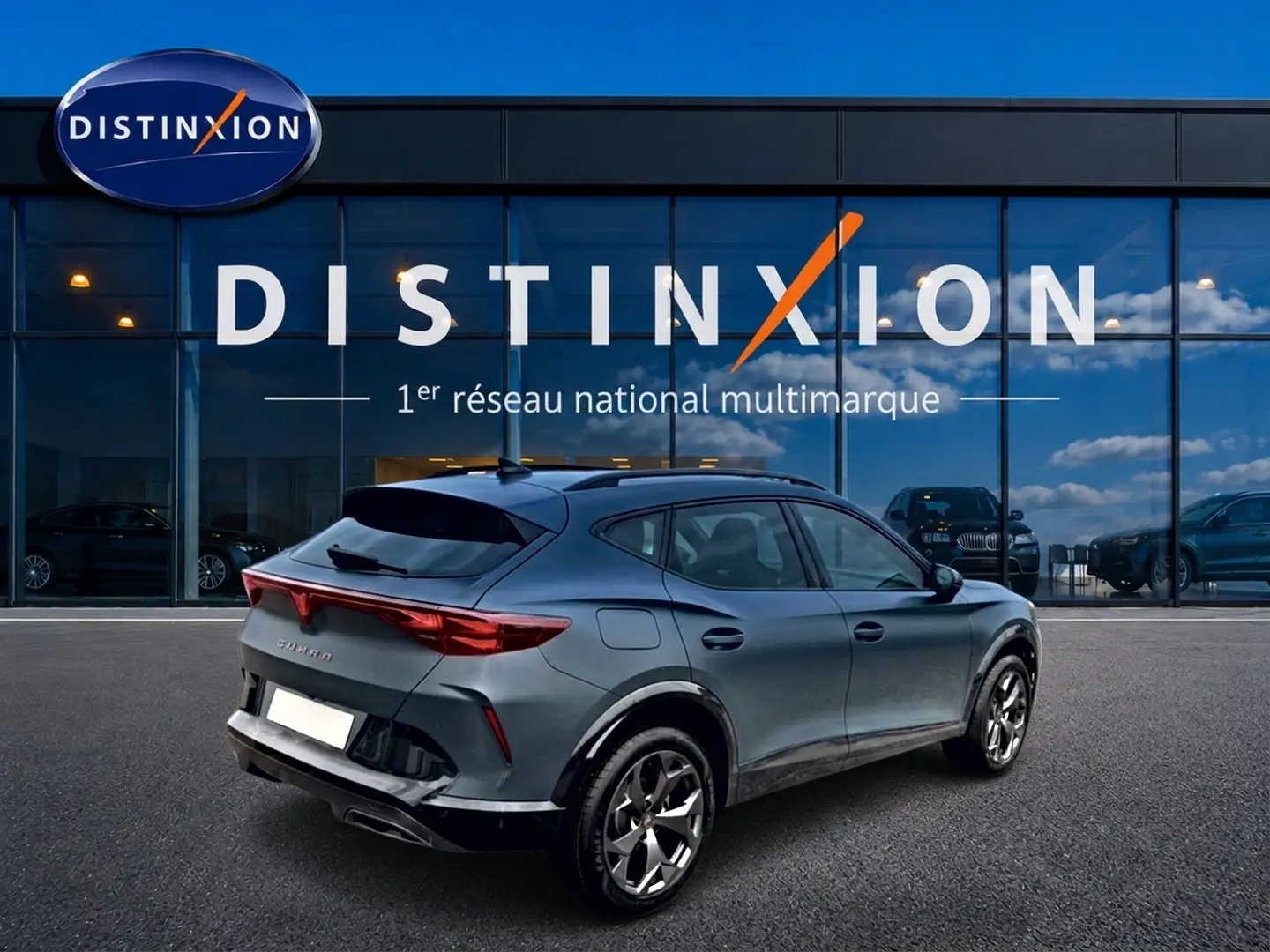 Vue 3/4 arrière droite d'un CUPRA Formentor 1.5 eTSI hybrid bleu fjord avec jantes 18 pouces devant un showroom Distinxion.