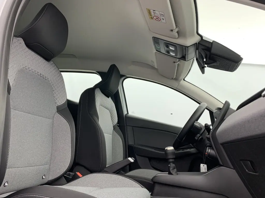 Intérieur avant droit de la Renault Clio V TCE 90 GSR2 Evolution avec sellerie textile gris à motif 3D et volant textile enduit grainé.