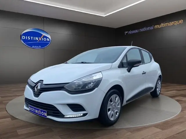 Renault Clio IV blanche vue en 3/4 avant droit dans un showroom avec logo Distinxion en arrière-plan.