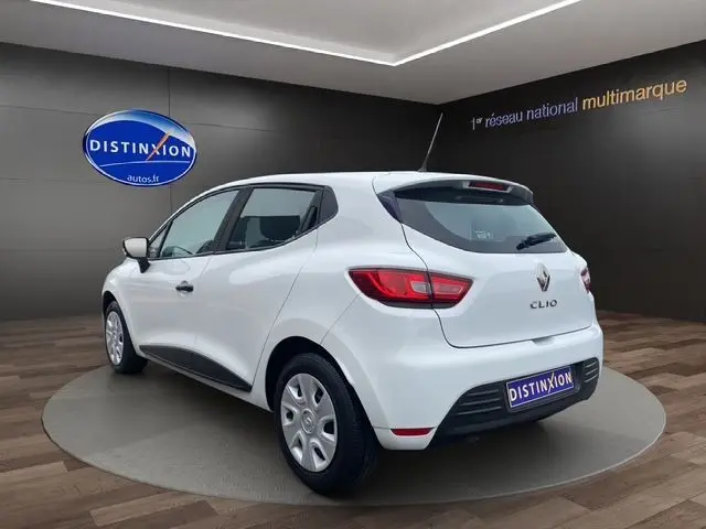 Vue 3/4 arrière droite d'une Renault Clio IV blanche de 2019, finition Société, dans un showroom Distinxion.