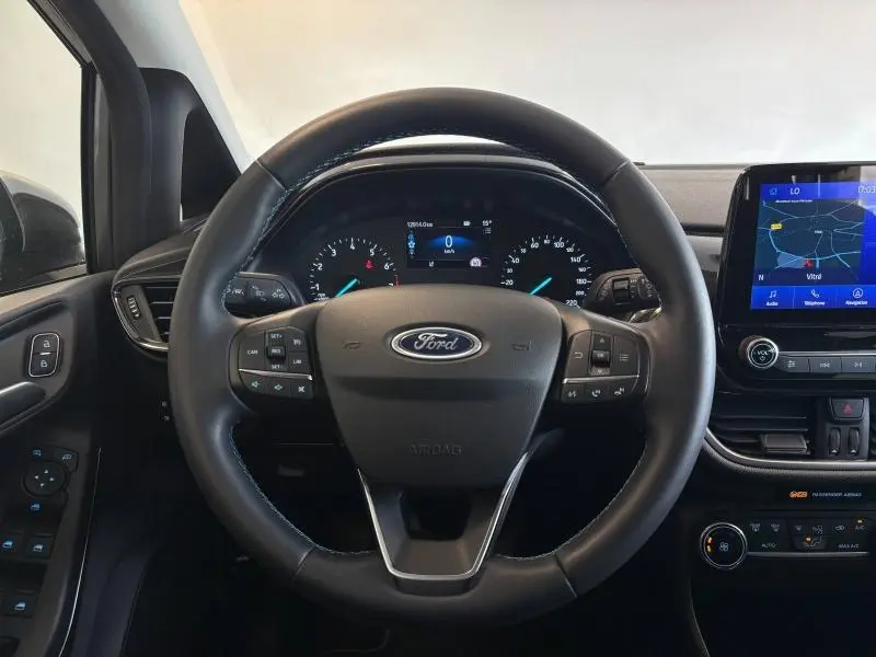 Vue frontale du volant en cuir noir et du tableau de bord numérique de la Ford Fiesta 2022 Fashion Gris Magnetic avec écran tactile GPS.