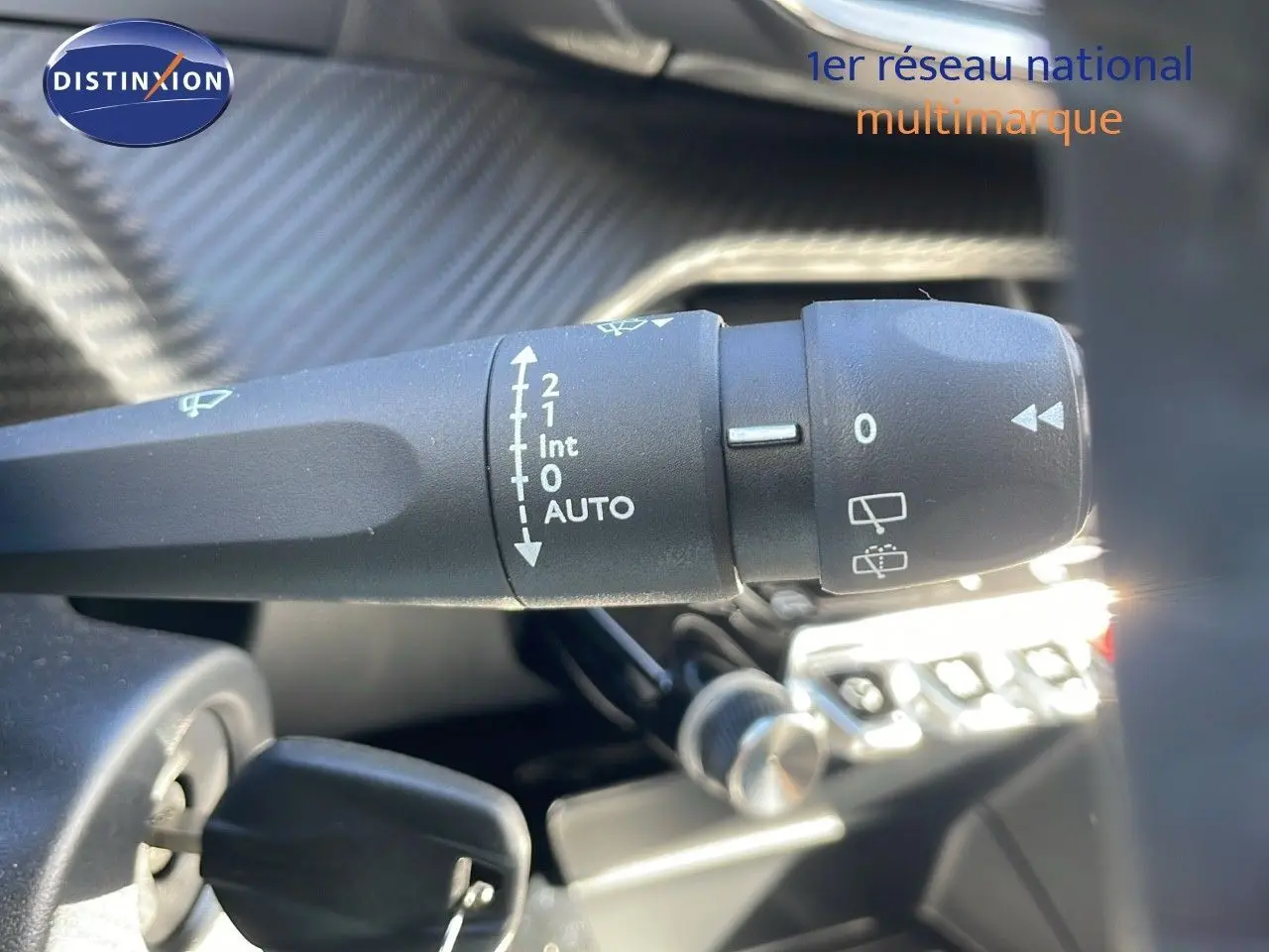 Gros plan sur la commande d'essuie-glace de la Peugeot 2008 blanche, mettant en valeur les réglages automatiques.