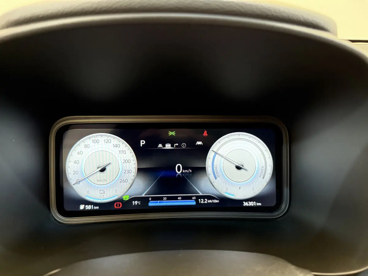 Gros plan sur le tableau de bord numérique du Hyundai Kona électrique 2022, affichant vitesse, autonomie et indicateurs.