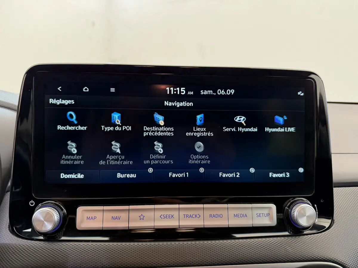 Écran tactile central de navigation de la Hyundai Kona électrique 2022, affichage clair et boutons fonctionnels en dessous.