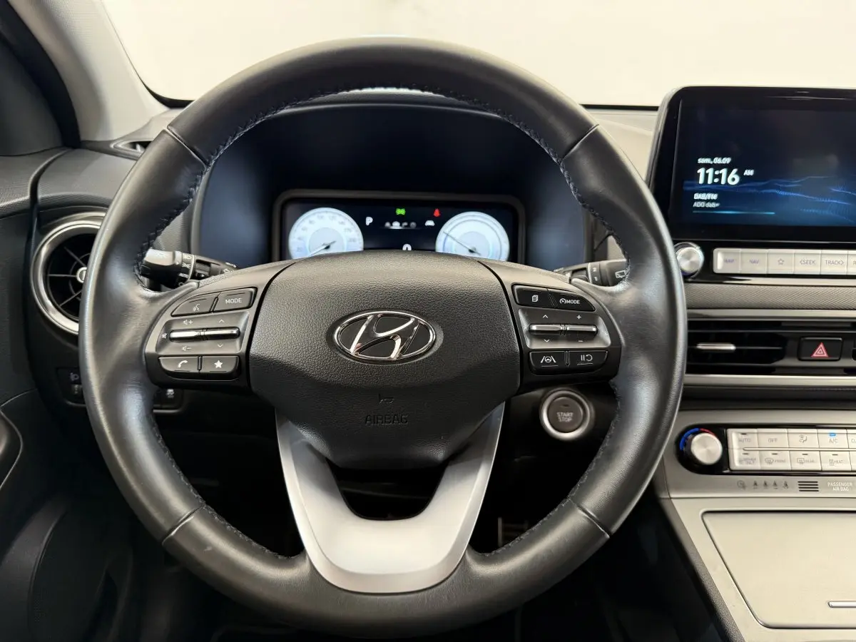 Vue centrée sur le volant cuir noir et le tableau de bord numérique du Hyundai Kona électrique 2022.
