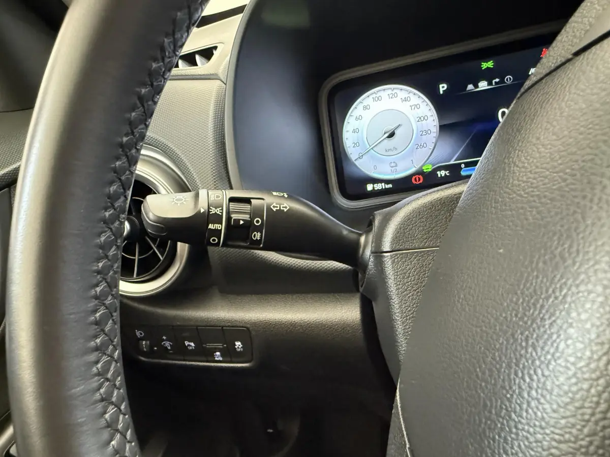 Gros plan sur le volant et le commodo gauche du tableau de bord du Hyundai Kona électrique gris clair 2022.