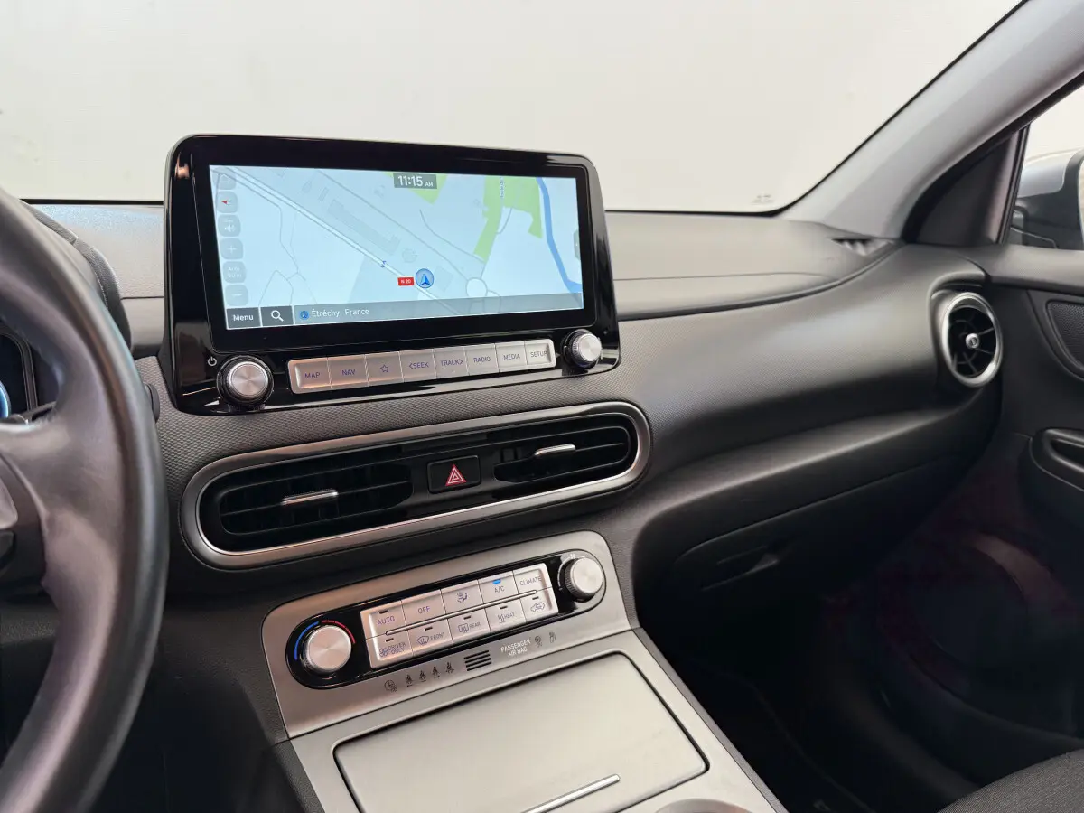 Vue intérieure côté passager du tableau de bord noir du Hyundai Kona électrique 2022 avec écran tactile de navigation allumé