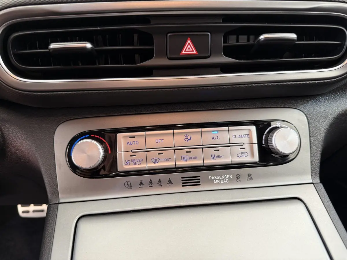 Gros plan sur la commande de climatisation argentée et noire du tableau de bord du Hyundai Kona gris clair 2022 électrique.