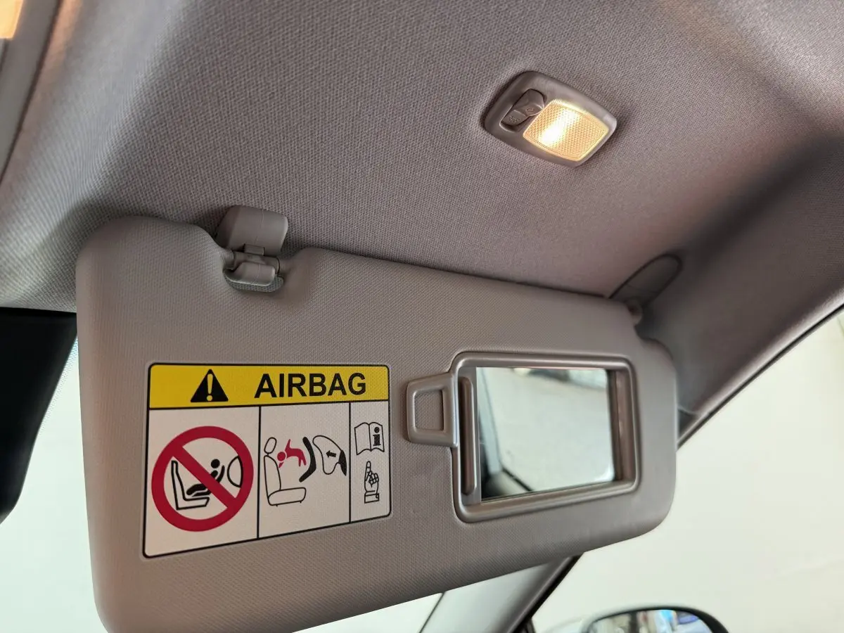 Détail du pare-soleil gris clair côté conducteur du Hyundai Kona 2022 avec miroir et avertissement airbag.