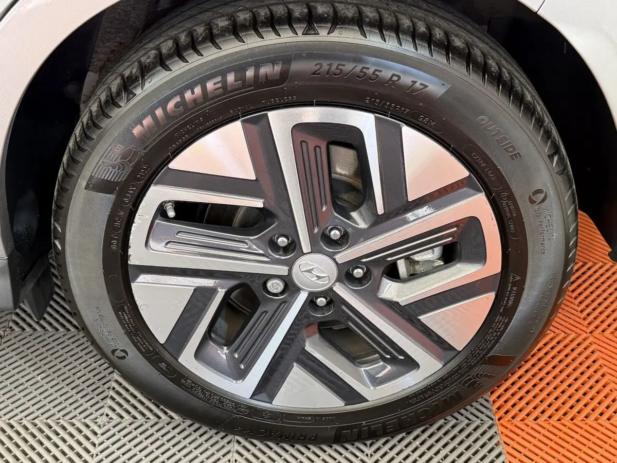 Gros plan sur la jante alliage et pneu Michelin du Hyundai Kona électrique gris clair, détail du design moderne.
