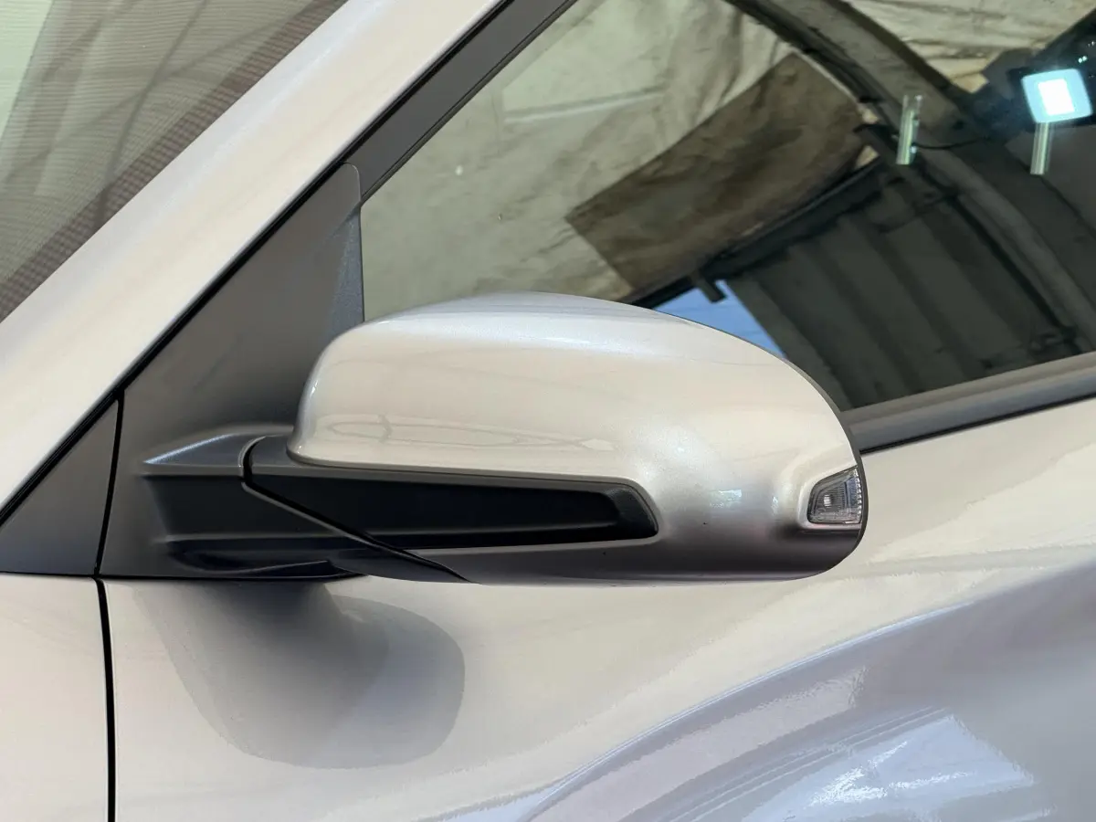 Rétroviseur côté conducteur gris clair du Hyundai Kona électrique 2022 avec clignotant intégré, vue rapprochée.