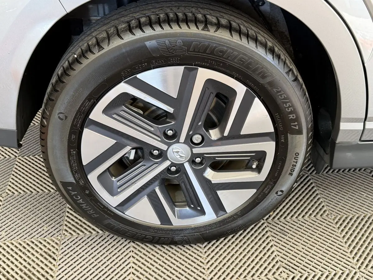 Gros plan sur la jante alliage gris et noir du Hyundai Kona électrique gris clair, avec pneu Michelin visible.