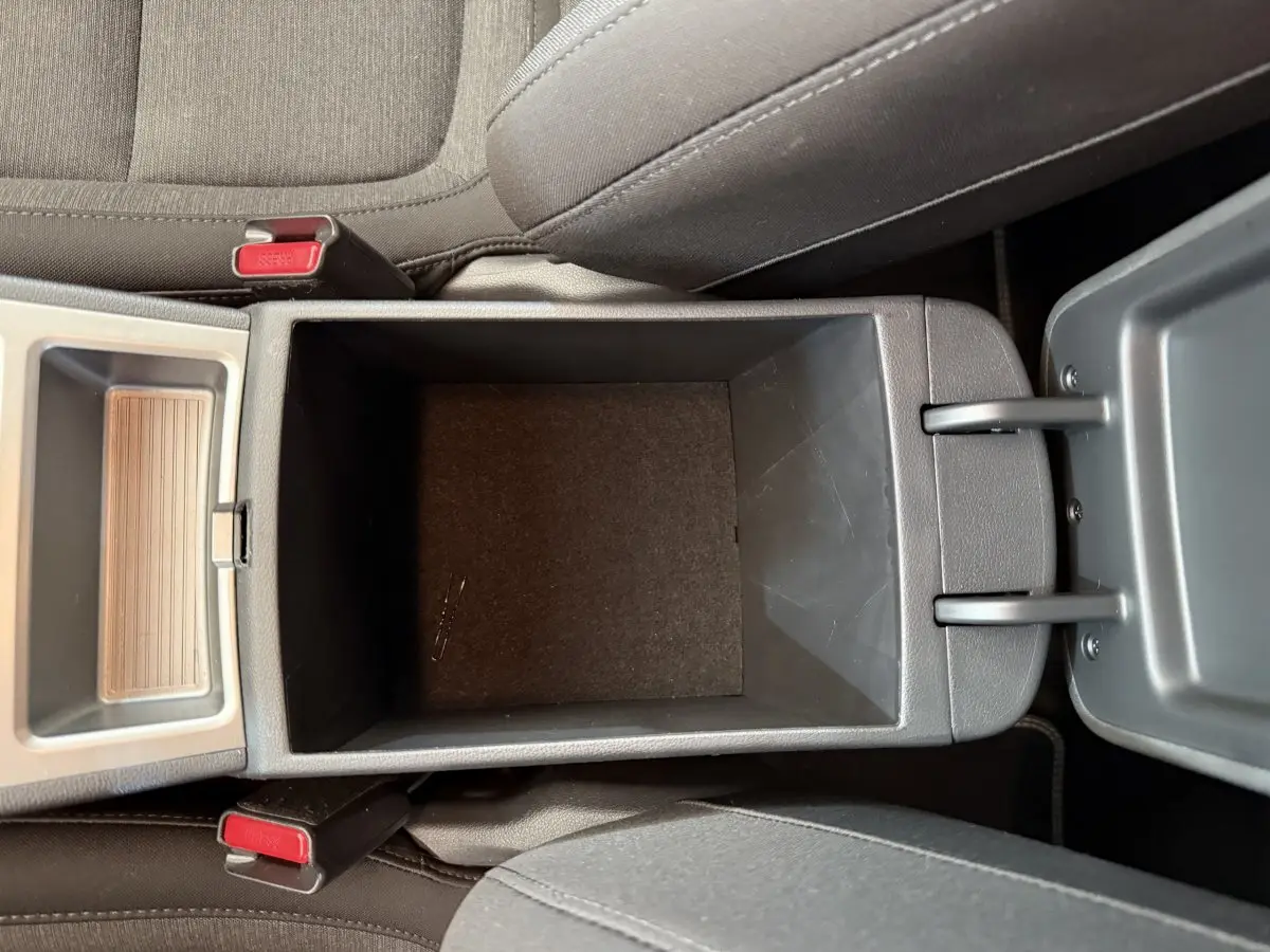 Vue plongeante sur le rangement central ouvert entre les sièges avant du Hyundai Kona gris clair électrique 2022.