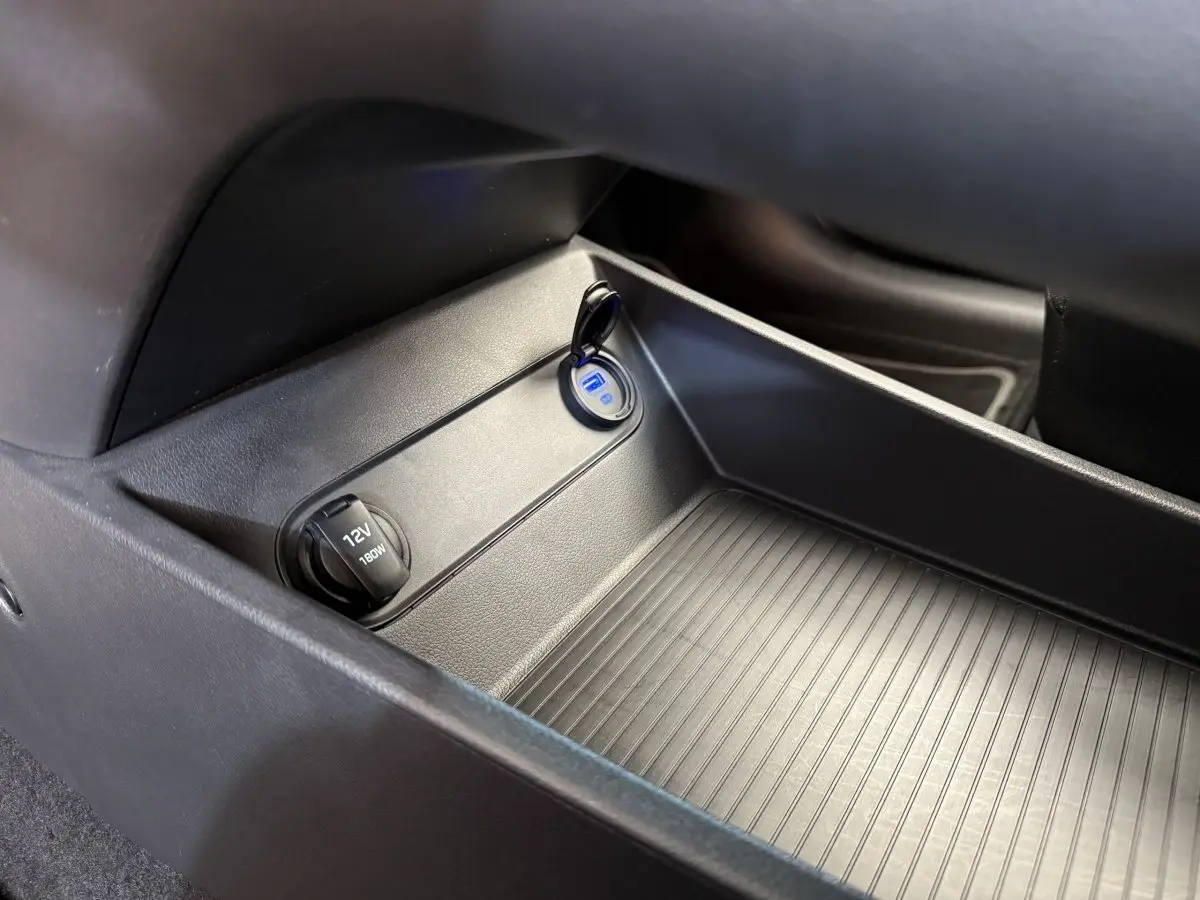 Prise 12V et port USB dans le rangement central intérieur du Hyundai Kona électrique gris clair 2022.