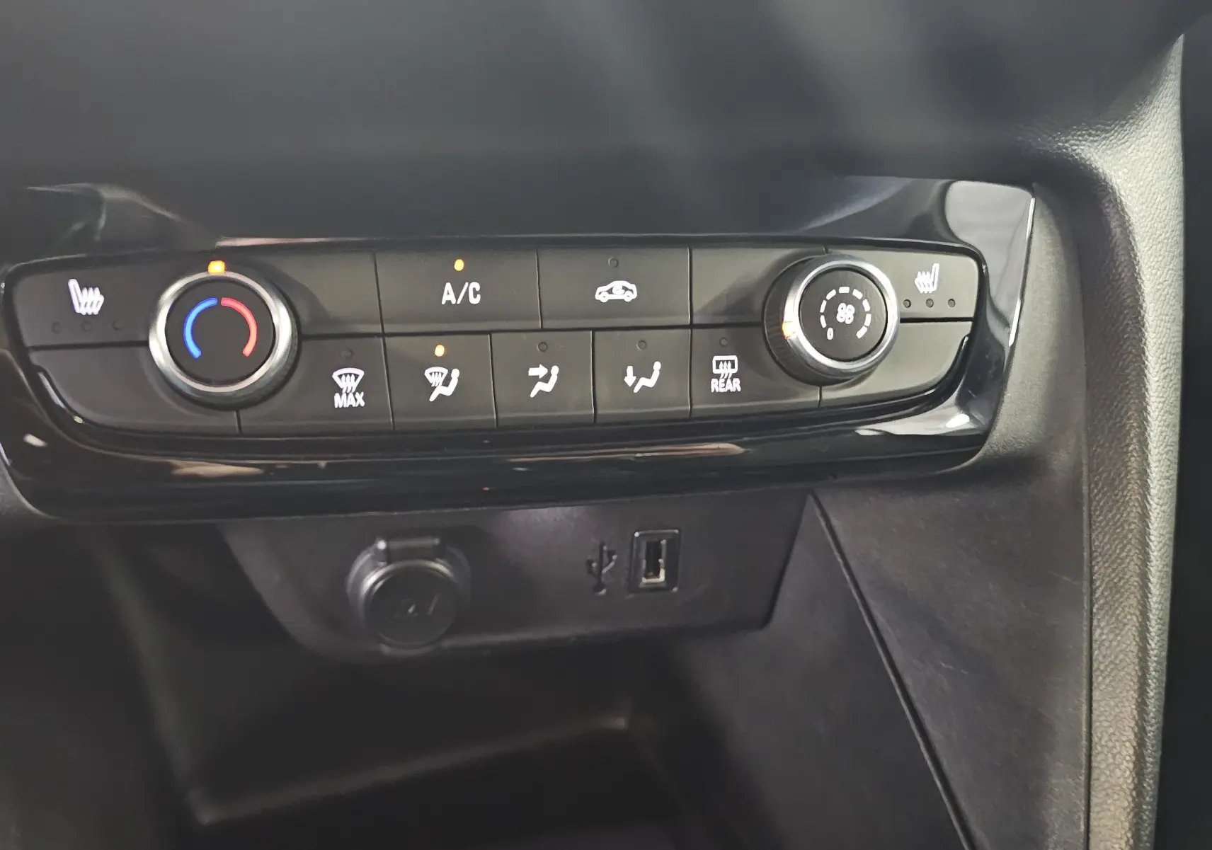 Vue rapprochée de la console centrale de l’Opel Corsa 2022, avec commandes de climatisation et ports USB visibles.