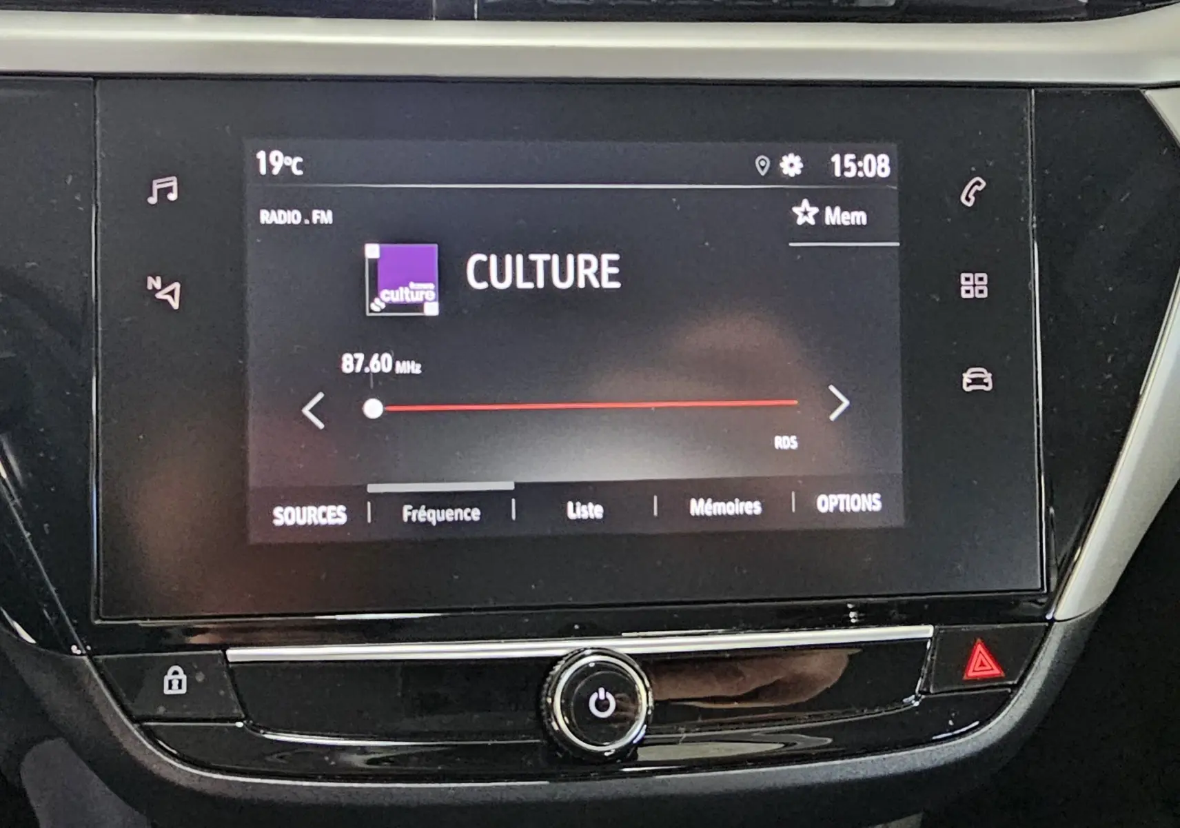 Écran tactile central de l’Opel Corsa blanc glacier 2022 affichant la radio FM sur la fréquence 87,60 MHz.