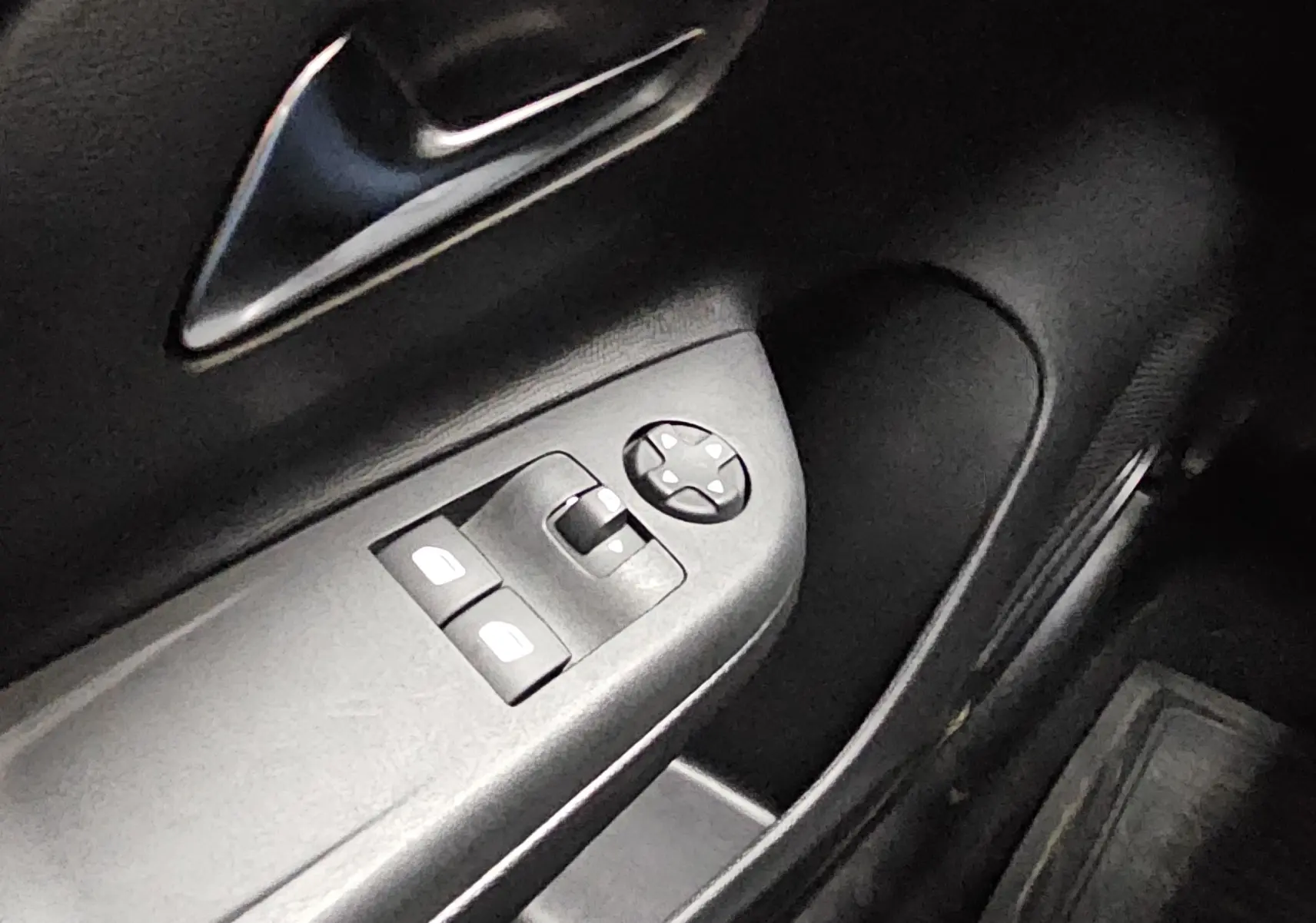 Gros plan sur la commande des vitres électriques côté conducteur de l’Opel Corsa blanc glacier 2022, intérieur noir.
