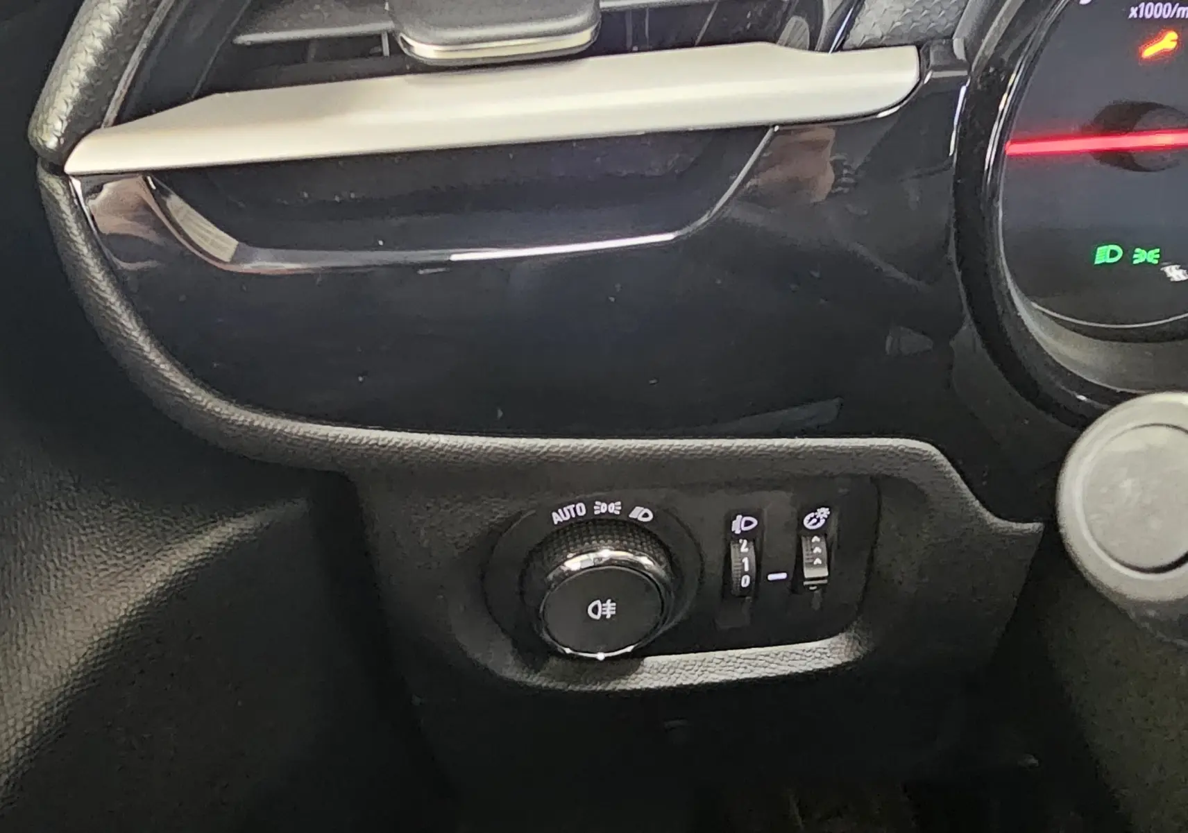 Détail du tableau de bord côté gauche de l’Opel Corsa blanc glacier, avec commandes d’éclairage et levier multifonction.