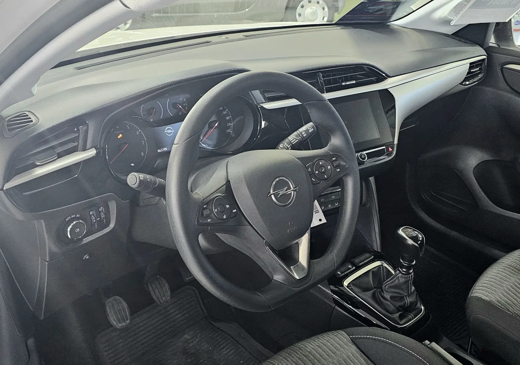 Vue intérieure côté conducteur de l’Opel Corsa blanc glacier 2022, volant multifonction et levier de vitesse manuel visibles.