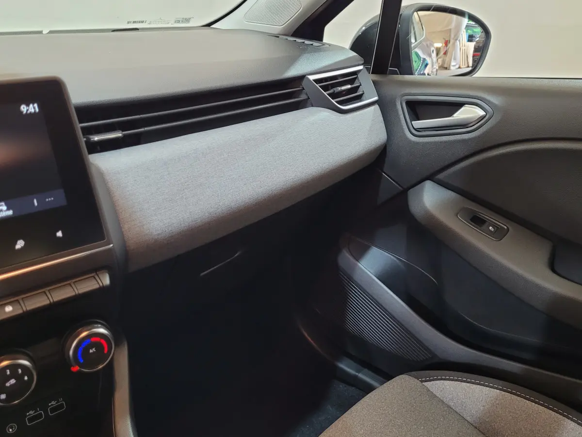 Intérieur côté passager de la Renault Clio Evolution Blue dCi 100 2025, tableau de bord gris clair et garnitures noires.