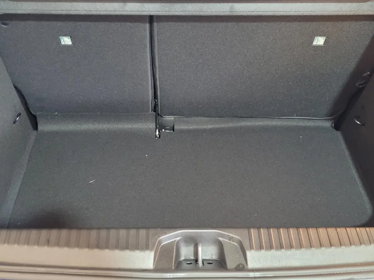 Coffre ouvert de la Renault Clio bleu, vue intérieure montrant l'espace de chargement avec banquette arrière rabattue.