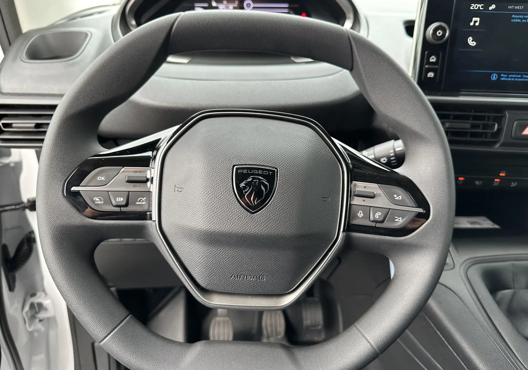 Volant multifonction noir du Peugeot Partner Fourgon BlueHDi 100ch M 2024, avec tableau de bord et écran tactile visibles.