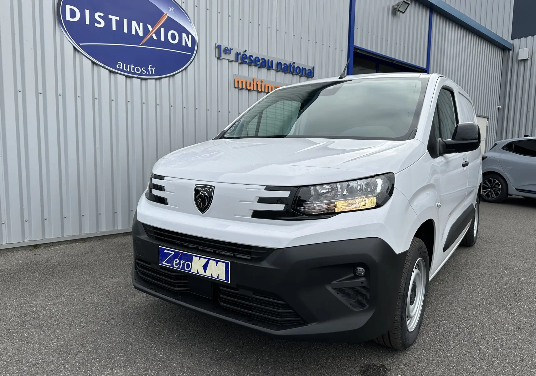 Peugeot Partner Fourgon blanc vu de trois quarts avant droit, avec calandre noire et plaque Zero KM visible.