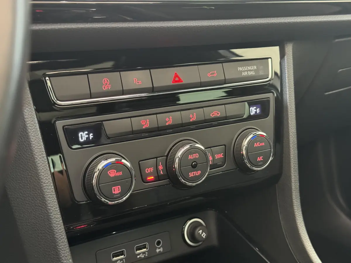 Gros plan sur la console centrale noire du SEAT Ateca 2019, montrant les commandes de climatisation et prises USB.