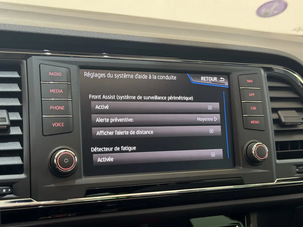 Écran tactile central du tableau de bord du SEAT Ateca gris clair, affichant les réglages d'aide à la conduite.