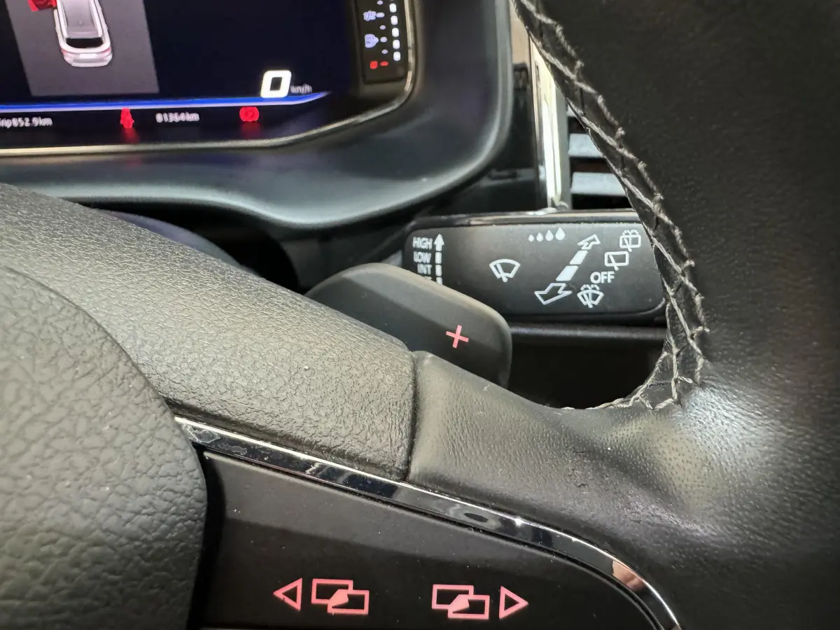 Gros plan sur le volant cuir noir d'un SEAT Ateca 2019 avec palettes de changement de vitesse et tableau de bord numérique.