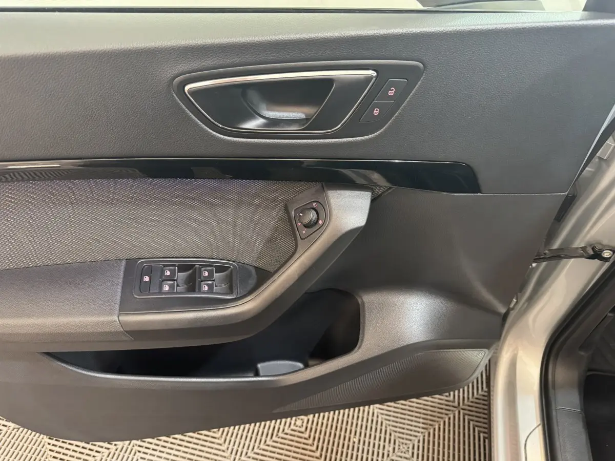 Intérieur côté conducteur de la SEAT Ateca gris clair, montrant la portière avec commandes des vitres et verrouillage.
