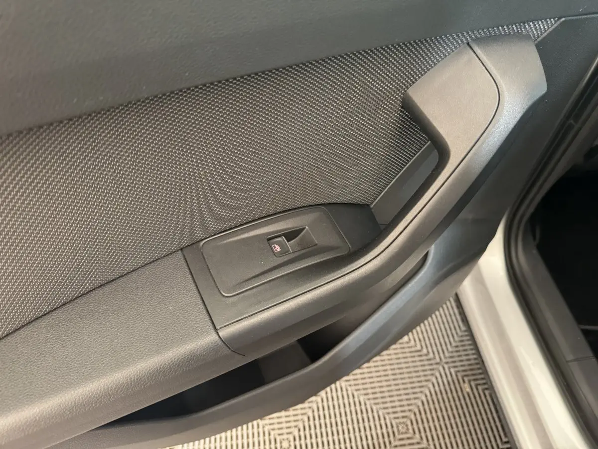 Détail de la poignée intérieure et commande de lève-vitre côté conducteur d'un SEAT Ateca gris clair.