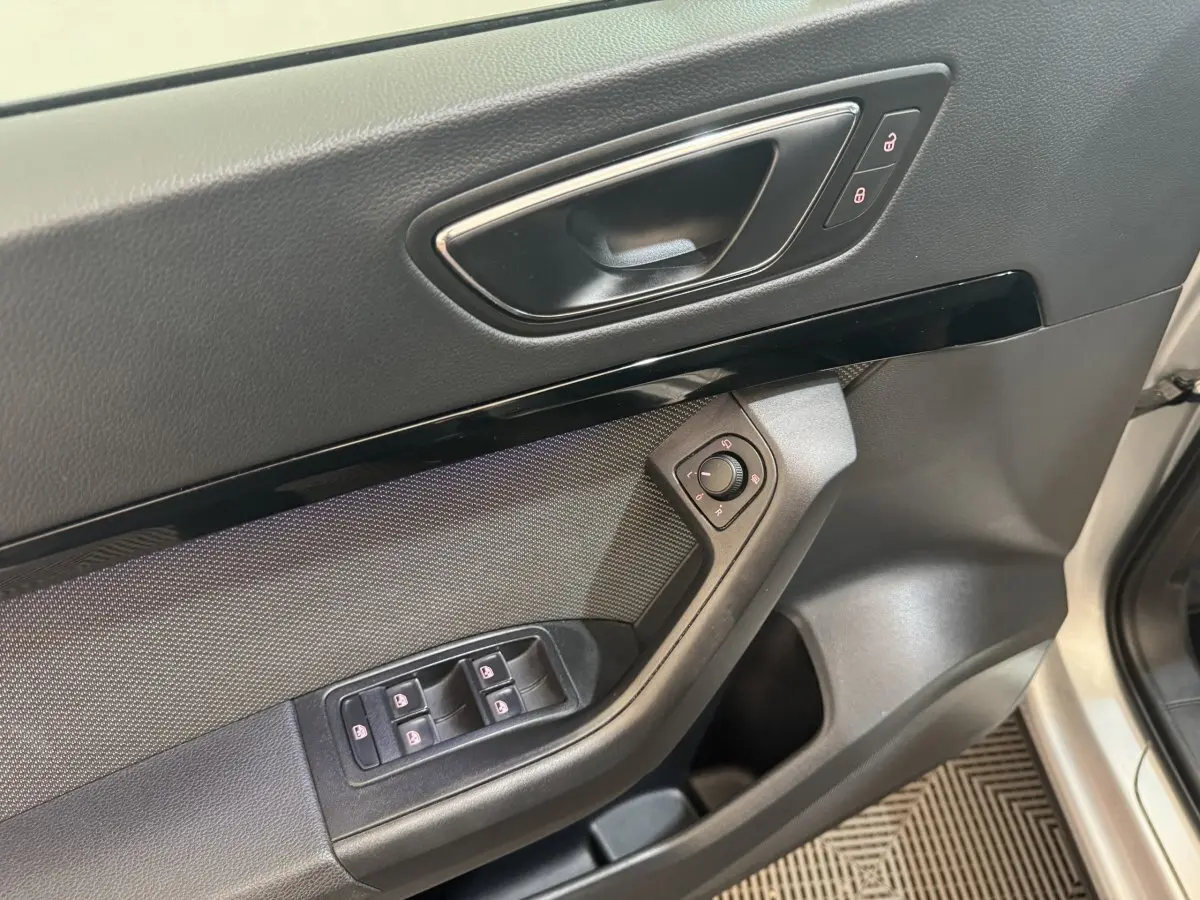 Poignée intérieure côté conducteur avec commandes des vitres et rétroviseurs du SEAT Ateca gris clair 2019.